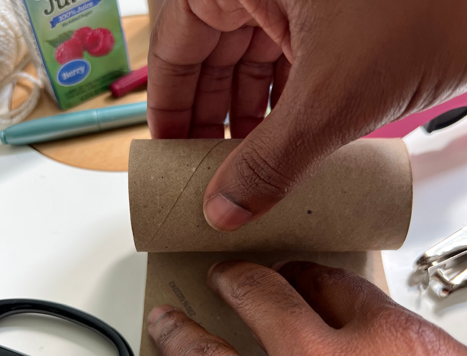 adult using a hot glue gun to build the binoculars