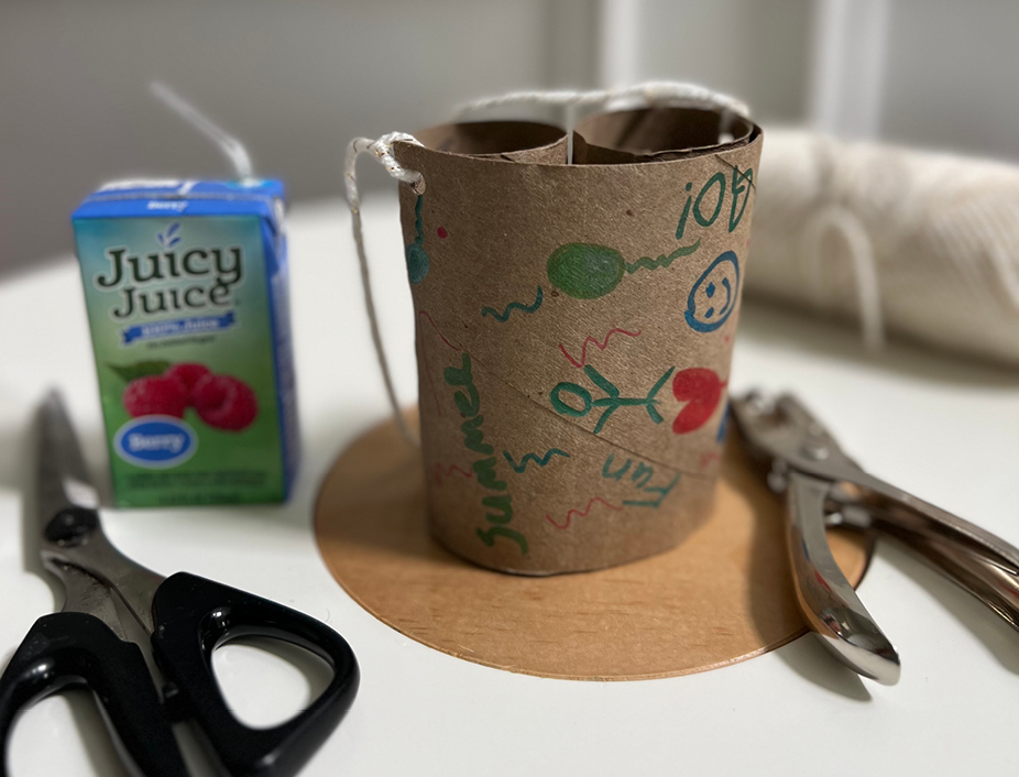 hole punching the binuculars/paper roll and putting a string through the hole punched hole