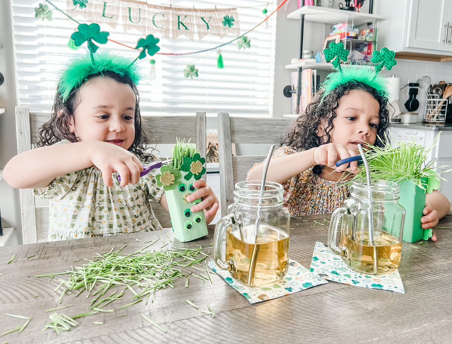 young girls trimming the wheat grass hair from their creatures